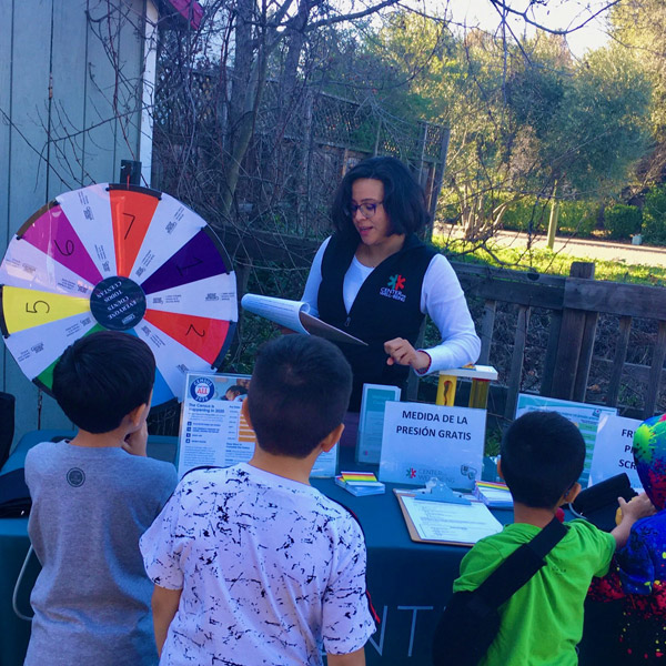 rosa talking to kids at a booth